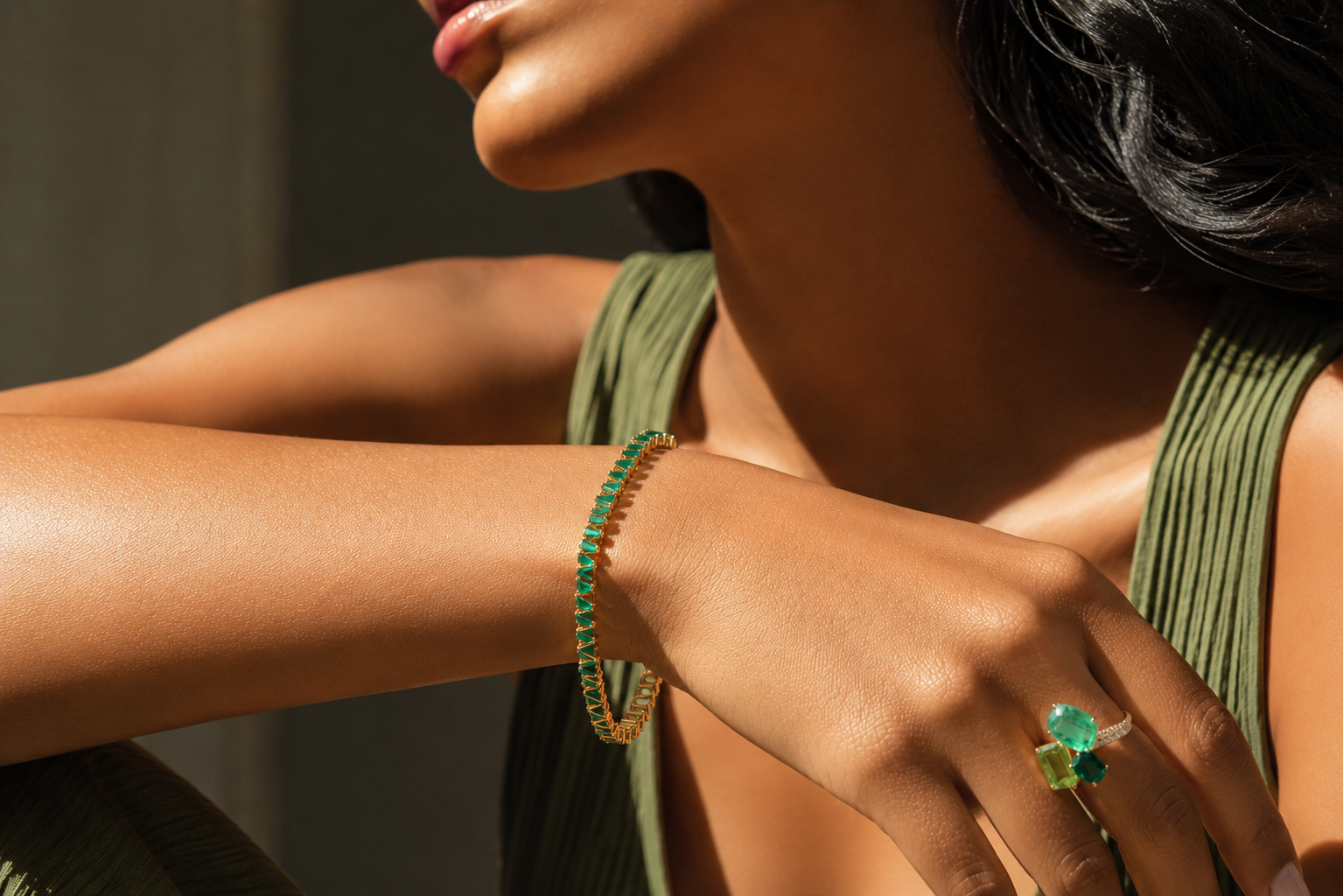 Emerald Bracelet and Emerald and Peridot Ring on a model with a green top.